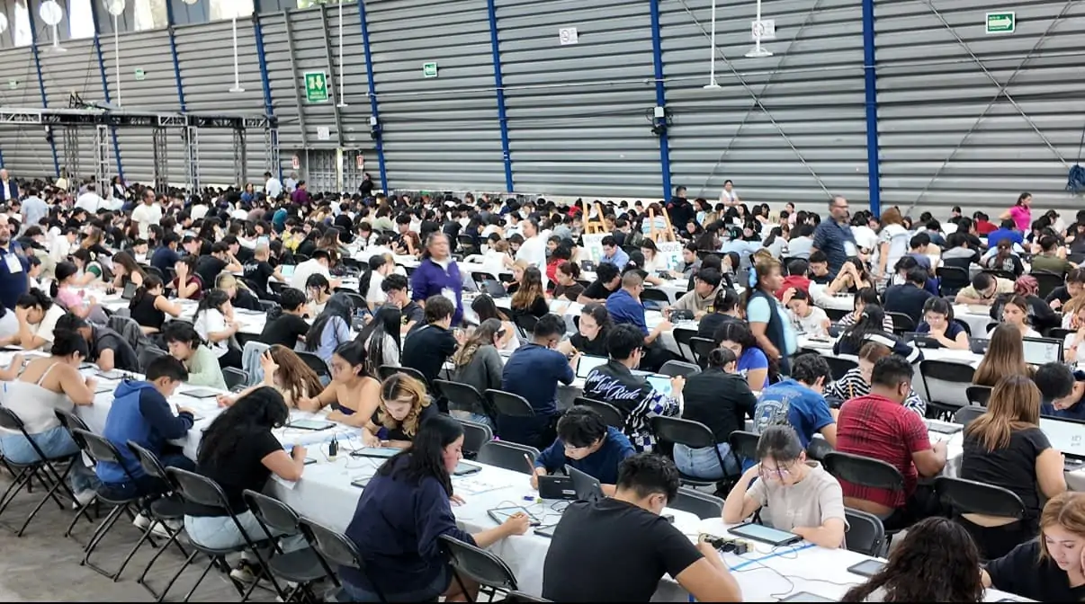 Aspirantes presentan el examen de control de la UNAM en mesas largas dentro del Palacio de los Deportes, en la Ciudad de México.